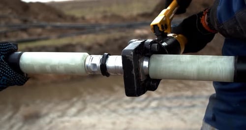 Worker Connects Cable with a Tool Close Up