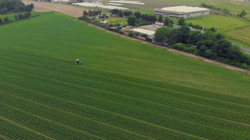 Aerial View of Tractor Working in Green Field