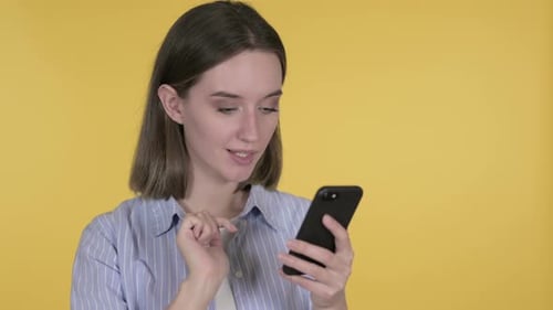Woman Reacts to Content on Smartphone, Expressing Shock