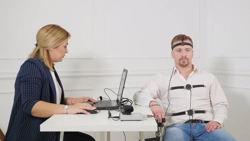 Woman Conducts a Polygraph Test on a Man
