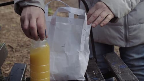 Desempacar almuerzo saludable para llevar en el banco del parque tiro medio