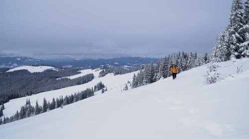 Man Hiking on Snowy Mountain in Winter