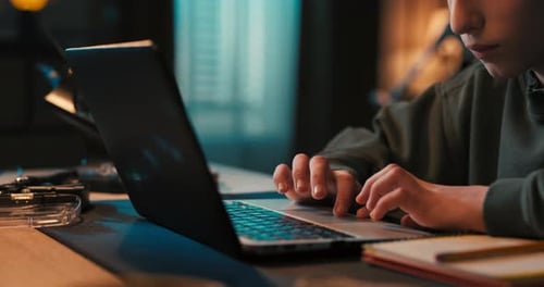 Teenager Using Laptop Computer at Desk Indoors