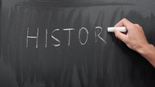 Hand Writes History on Blackboard with Chalk