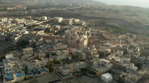 Church in Middle of Small Mediterranean Town in Beige and Brown Sand Color on Malta Island, Aerial