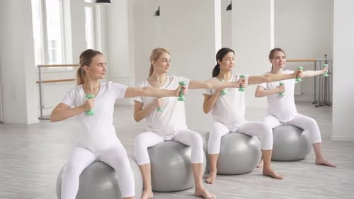 Pregnant Women Exercising with Weights on Exercise Balls