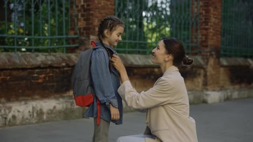 Happy Mother Escorts Child to School