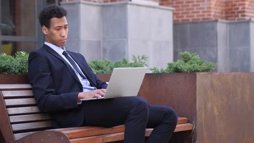 Pensive Designer Thinking While Working on Laptop