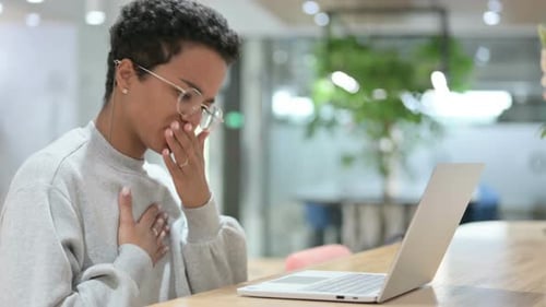 Young Adult Coughs While Using Laptop