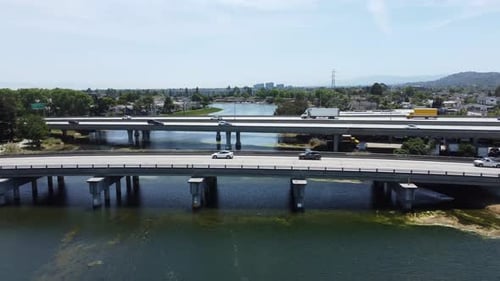 Überholaufnahme von zwei Brücken, die mit Autos beschäftigt sind, die die wunderschöne lange Lagune überqueren, San Mateo, Kalifornien