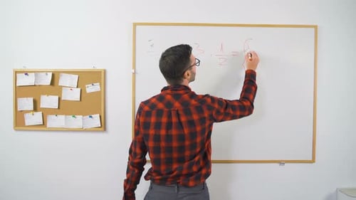 Adult Writing Math Problems on Whiteboard