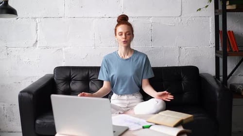 Woman Meditating on Couch During Work Break