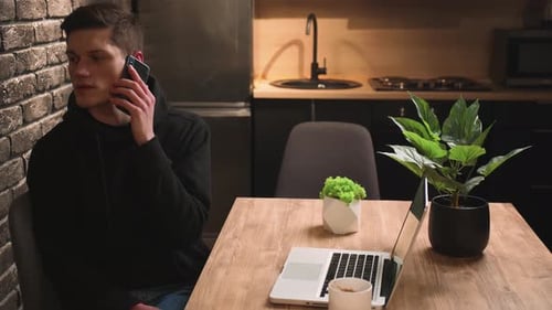 Handsome Smiling Man Talking Mobile Phone at Home Office