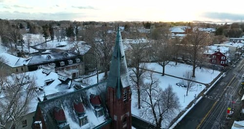 Lititz Pennsylvania PA establishing shot in winter snow. Aerial orbit tilt down on Christian church.