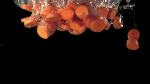 Superzeitlupe Karottenstücke fallen unter Wasser