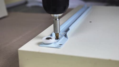 Screwdriver Installing Hardware with Screw on White Board