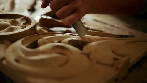 Craftsman Carving Wood with Chisel and Mallet