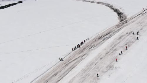 Group of People Climbs Snowy Mountains of Elbrus Along Road