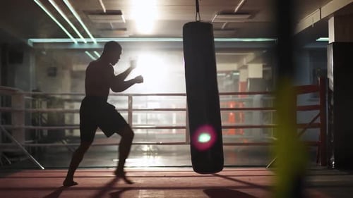 Man Boxing Punching Bag in Gym