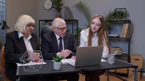 Three Colleagues Discussing Data on a Laptop