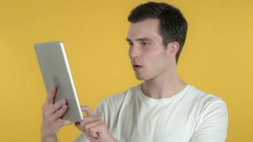 Man reacts with shock while holding tablet