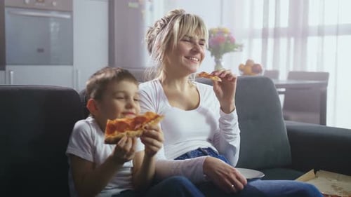 Mother and Child Enjoying Pizza Together at Home