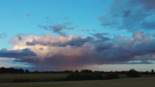 Erntefeld nach Regen und Gewitterwolken im Hintergrund ländlicher Landschaft. Drohnen-Shot