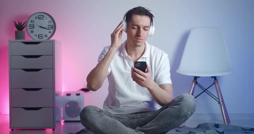 Man Listening to Music and Using Smartphone Indoors