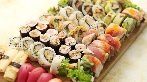 Ansicht von oben auf Holzbrett platzierte Sushi und Rollen