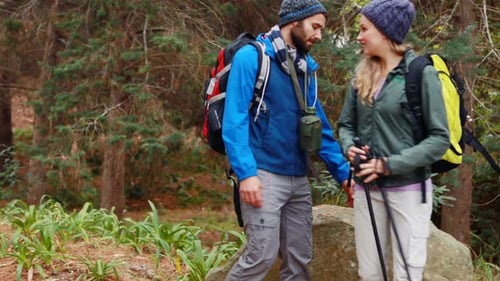 Hiker couple interacting with each other in forest