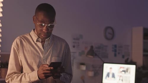 Businessman Recording Voice Message in Office at Night