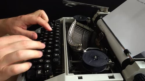 Person Typing on a Classic White Typewriter