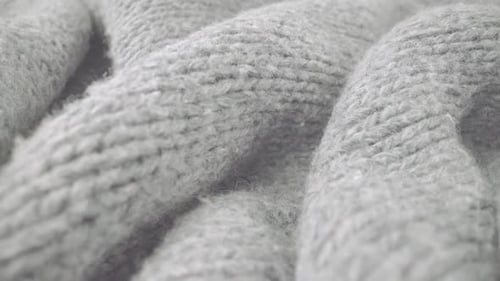 Extreme detail view of sheep wool cloth texture flowing in macro dolly shot.