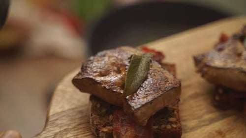 Anonymous chef garnishing steak with bay leaves