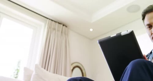 Man Relaxing at Home Using a Tablet