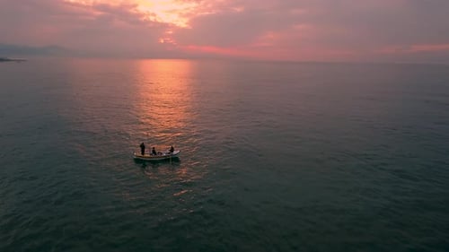 Boat Travels Across Ocean at Sunrise or Sunset