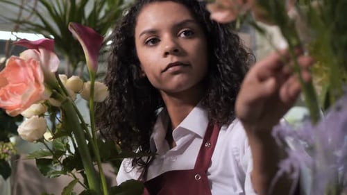 Jeune fleuriste faisant la composition de fleurs fraîches