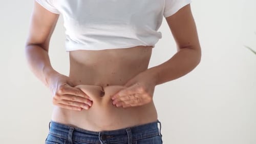 Woman Pinching Skin on Abdomen