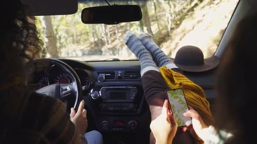 Mann fährt Auto entlang der Straße Freundin liest Karte am Telefon