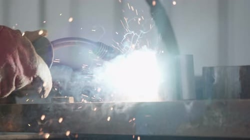 Slow motion of a welder welding construction steel frames