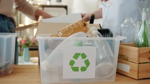 Recyclable Items Being Placed in Recycling Bin