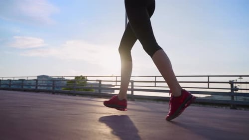 Slender Woman is Jogging Alone in Early Morning in City in Summer Day Closeup of Female Legs