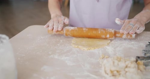 Close-up of Womans Hands Rolling Dough Cooking Home-made Pastry at Table