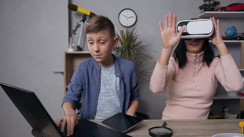 Excited Woman Using VR Headset with Boy Nearby