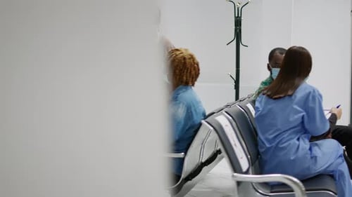 Multiethnic Group of People with Face Masks Sitting in Hospital Reception