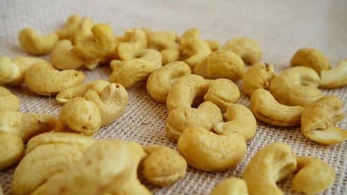 Cashews Falling onto Burlap Surface
