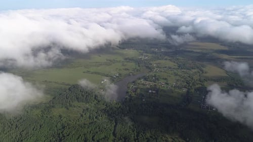 Very Slow and Smooth Flight Above the Clouds. Low Cumulus Cloud Cover. Below You Can See the Rural