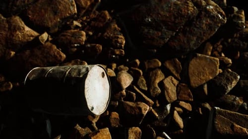 Rusty Destroyed Metal Barrel on Beach Rocks