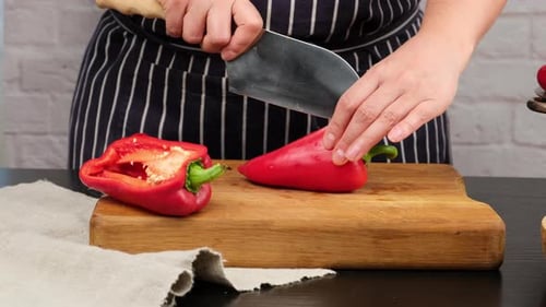 Chopping Red Bell Pepper with Knife on Cutting Board