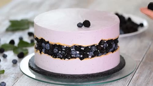 Decorating Delicious Cake with Fresh Blueberries and Blackberries